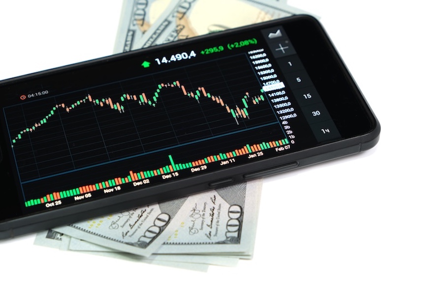 Stock exchange chart on smartphone screen and hundred dollar bills on white background.Concept,shares, business and finance.